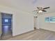 Bright bedroom boasts wood flooring, a ceiling fan, and natural light from a window at 10922 Park Dr, Riverview, FL 33569