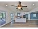 Open kitchen boasts a central island with black countertops, and stainless steel appliances with a view to an outdoor deck at 10922 Park Dr, Riverview, FL 33569
