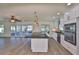 Open concept kitchen with an island cooktop, stainless appliances, a view of the deck, and white cabinetry at 10922 Park Dr, Riverview, FL 33569