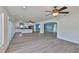 Spacious living room featuring an open concept layout with a kitchen, ceiling fans, and sliding glass doors to a deck at 10922 Park Dr, Riverview, FL 33569