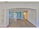 Living room features white trim, neutral wood-look flooring, an archway, and a sliding closet door at 10922 Park Dr, Riverview, FL 33569