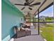 Cozy covered patio with wicker seating and ceiling fans overlooking a picturesque waterfront at 10922 Park Dr, Riverview, FL 33569