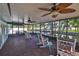 Relaxing screened porch with rocking chairs and ceiling fans overlooking a scenic waterfront view at 10922 Park Dr, Riverview, FL 33569