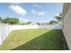 View of a large grassy backyard enclosed by a white privacy fence, perfect for outdoor activities and privacy at 11021 Silver Dancer Dr, Riverview, FL 33579