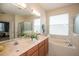 Bright bathroom with double vanity, garden tub, glass shower and white tile backsplash at 11021 Silver Dancer Dr, Riverview, FL 33579