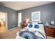 Comfortable bedroom featuring carpet, blue accent wall, and natural light at 11021 Silver Dancer Dr, Riverview, FL 33579