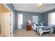 Comfortable bedroom featuring carpet, blue accent wall, and natural light at 11021 Silver Dancer Dr, Riverview, FL 33579