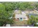 Aerial view of a property showcasing the backyard with a patio set, surrounded by lush greenery and mature trees at 11315 N Armenia Ave, Tampa, FL 33612