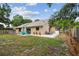 Spacious backyard features a patio with blue outdoor furniture, a well-maintained lawn, and a charming neutral-toned home exterior at 11315 N Armenia Ave, Tampa, FL 33612