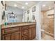 Bathroom vanity features granite countertop, dual sinks, wood cabinetry and a tiled walk-in shower at 11315 N Armenia Ave, Tampa, FL 33612