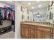 Bathroom vanity features granite countertop, dual sinks, wood cabinetry and walk-in closet at 11315 N Armenia Ave, Tampa, FL 33612