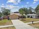Charming one-story home with a well-maintained lawn, complemented by a sunny sky and mature trees at 11315 N Armenia Ave, Tampa, FL 33612