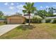 Charming single-Gathering home featuring a front yard, mature palm tree, and attached two-car garage at 11315 N Armenia Ave, Tampa, FL 33612