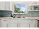 Kitchen featuring granite countertops, stainless steel faucet, and a window overlooking the backyard at 11315 N Armenia Ave, Tampa, FL 33612