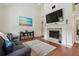 Well-lit living room featuring a fireplace, TV, and decor with a beach-inspired painting at 11315 N Armenia Ave, Tampa, FL 33612