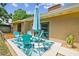Outdoor patio with stylish blue seating, an umbrella for shade, and easy access to indoor living through sliding glass doors at 11315 N Armenia Ave, Tampa, FL 33612