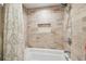 Bathtub with tiled walls, recessed shelf and shower head at 11315 N Armenia Ave, Tampa, FL 33612
