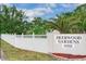 Entrance to Deerwood Gardens community featuring a white fence and manicured landscaping at 11511 113Th St # 5C, Largo, FL 33778
