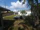 Spacious backyard featuring a concrete patio, mature trees, and partial fencing at 116 S Arrawana Ave, Tampa, FL 33609