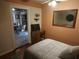 Cozy bedroom featuring a ceiling fan, wooden desk, and view to an adjacent seating and dining area at 116 S Arrawana Ave, Tampa, FL 33609