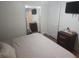 Cozy bedroom with a mounted TV, dresser, large mirror, and neutral bedding at 116 S Arrawana Ave, Tampa, FL 33609