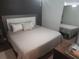 Neutral bedroom features a queen bed with soft pillows and light quilt with a small side table at 116 S Arrawana Ave, Tampa, FL 33609