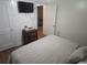 This comfy bedroom features a mounted TV, dresser, and neutral bedding at 116 S Arrawana Ave, Tampa, FL 33609