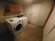 A functional laundry room with modern washing machine and dryer with overhead cabinets for storage at 116 S Arrawana Ave, Tampa, FL 33609