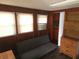 A functional room featuring wood paneling, futon, and new floors at 116 S Arrawana Ave, Tampa, FL 33609