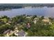 Aerial view featuring a lakeside home nestled among lush trees and picturesque landscape at 12002 Hope Ln, Tampa, FL 33618