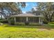 Expansive backyard with lush green lawn and a screened-in porch at 12002 Hope Ln, Tampa, FL 33618