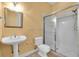 Bathroom with pedestal sink, toilet, and tiled shower with glass doors at 12002 Hope Ln, Tampa, FL 33618