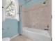 The bathroom offers a shower-tub combination with tiled surround and a bright window at 12002 Hope Ln, Tampa, FL 33618