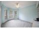Cozy bedroom with large windows, soft carpeting, and a relaxing ceiling fan at 12002 Hope Ln, Tampa, FL 33618