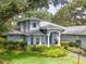 Beautiful two-story single-Gathering home with mature landscaping, trees, and blue exterior paint at 12002 Hope Ln, Tampa, FL 33618