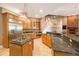 A spacious kitchen with wood cabinetry, granite counters, a breakfast bar, and stainless steel appliances at 12002 Hope Ln, Tampa, FL 33618