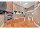 Open floor plan living room with brick fireplace, wood floors and many windows at 12002 Hope Ln, Tampa, FL 33618