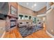 Virtual staging of living room featuring brick fireplace, wood floors and modern furnishings at 12002 Hope Ln, Tampa, FL 33618