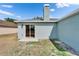Backyard exterior featuring a sliding glass door, chimney, and light blue siding at 12119 Buffington Ln, Riverview, FL 33579