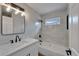 Modern bathroom featuring a tub shower with tile surround, white vanity and black hardware and fixtures at 12119 Buffington Ln, Riverview, FL 33579