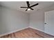 Clean bedroom features wood-look flooring, ceiling fan, and door; natural light fills the room at 12119 Buffington Ln, Riverview, FL 33579