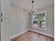 Bright dining room with wood floors, modern lighting, and a large window overlooking the front yard at 12119 Buffington Ln, Riverview, FL 33579