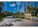 Woodlake Run community sign shows the entrance with lush landscaping, trees, and an American flag at 124 Woodlake Wynde, Oldsmar, FL 34677