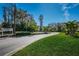 A view of the lush landscaping, trees, and American flag at the entrance to the Woodlake Run community at 124 Woodlake Wynde, Oldsmar, FL 34677