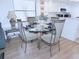 Dining room features a glass top table and seating for four adjacent to the open concept kitchen at 124 Woodlake Wynde, Oldsmar, FL 34677
