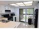 Bright kitchen with white cabinets and black appliances, and a sliding glass door to the outside at 124 Woodlake Wynde, Oldsmar, FL 34677