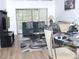 Bright living space boasts wood floors, modern sofas, glass table and slider access to an outdoor patio at 124 Woodlake Wynde, Oldsmar, FL 34677