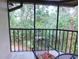 Charming screened lanai with metal chairs and a table, offering views of lush landscaping at 124 Woodlake Wynde, Oldsmar, FL 34677