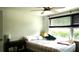 Relaxing bedroom with a ceiling fan, natural light, and plaid bedding at 12407 Partridge Hill Row, Hudson, FL 34667
