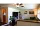 Inviting living room featuring a ceiling fan, stylish decor, and an adjacent kitchen with wood cabinets at 12407 Partridge Hill Row, Hudson, FL 34667